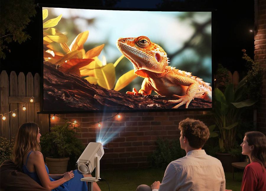 Projecteur Aurzen BOOM air Full HD diffusant un film en ext&eacute;rieur sur grand &eacute;cran lors d&rsquo;une soir&eacute;e cin&eacute;ma en plein air.