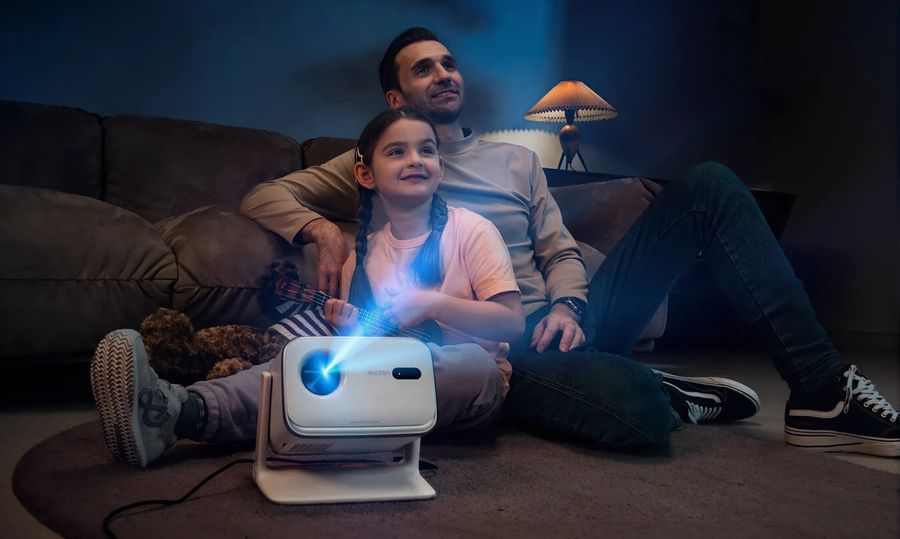 Projecteur Aurzen BOOM mini utilis&eacute; dans un salon familial pour diffuser une image lumineuse lors d&rsquo;un moment de divertissement &agrave; domicile.