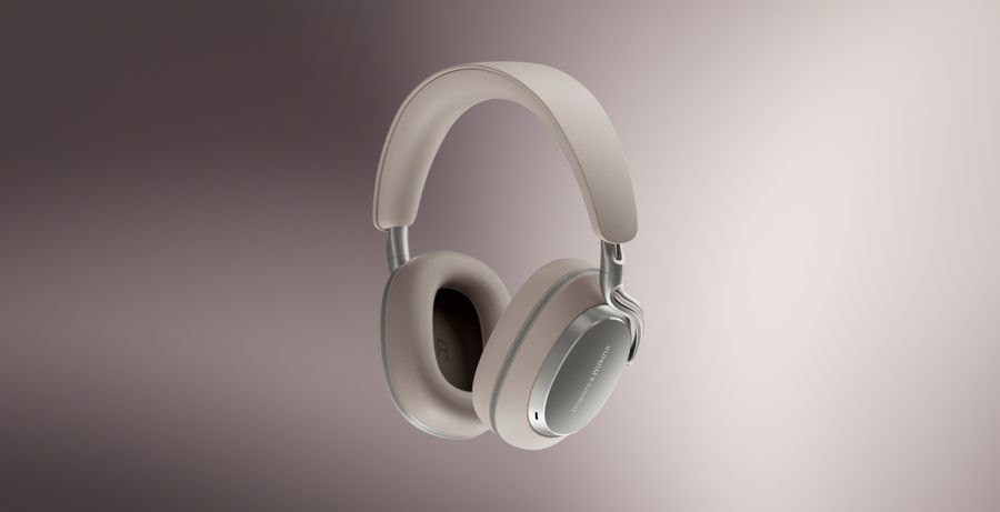 Casque Bluetooth Bowers & Wilkins PX8 S2 en finition beige, suspendu sur un fond dégradé rose et beige.