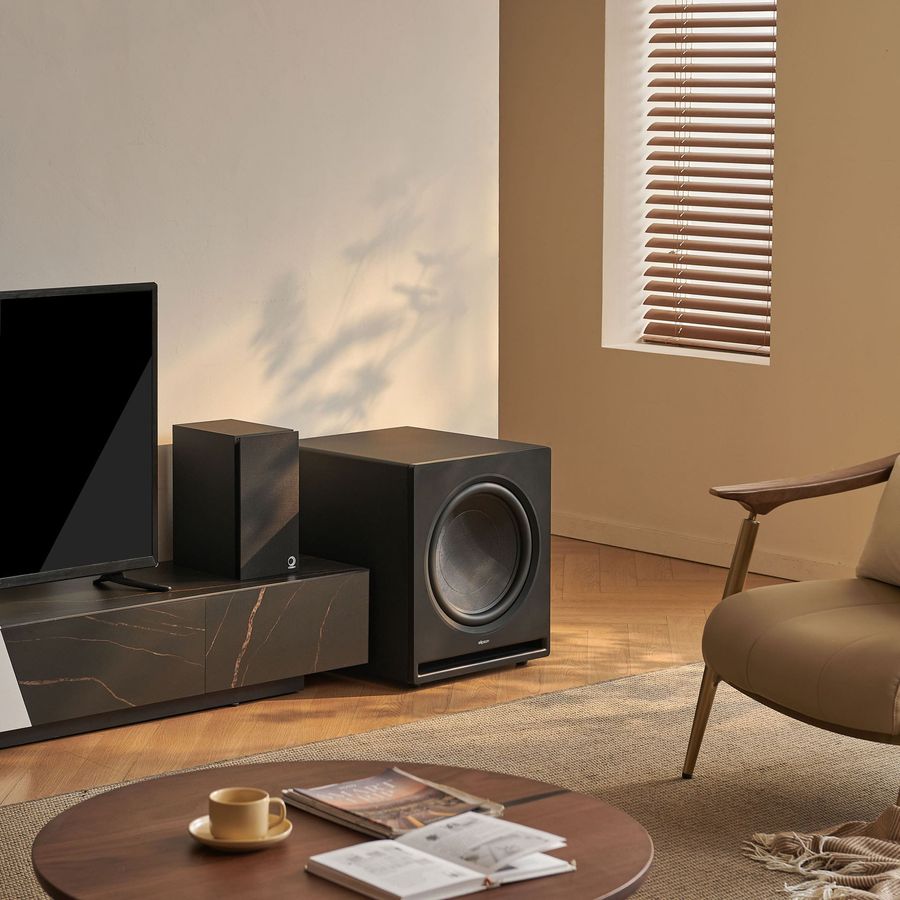 Caisson de basses Elipson Premium SUB 15 Caisson de basses Elipson Premium SUB 15 noir, placé dans un salon moderne à côté d'une enceinte et d'un téléviseur.
