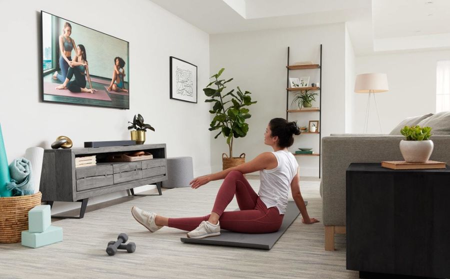 Barre de son JBL Bar 300 : mise en situation avec femme faisant une séance de sport devant la TV