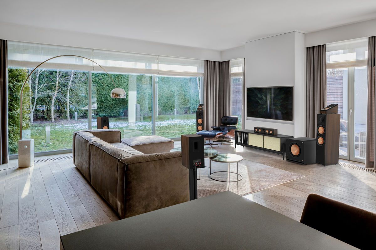 Caisson de basses Klipsch RP-1400SW installé dans un salon moderne et lumineux avec de grandes baies vitrées.