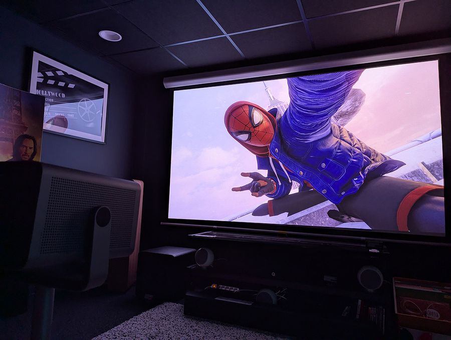 Scène de jeu Spider-Man sur PS5 projetée par le projecteur Leica Cine Play 1 dans une salle dédiée.