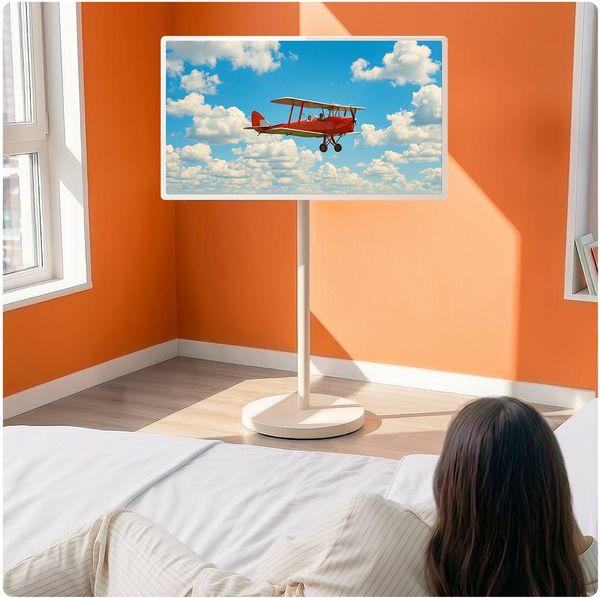 LG StanbyME 2 Max (32LX6BPGA) dans une chambre affichant l'image d'un avion biplan rouge volant dans un ciel nuageux