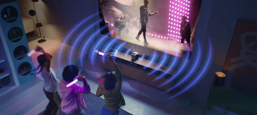 Vidéoprojecteur LG CineBeam S (LG PU615U) diffusant un concert avec des effets visuels illustrant la qualité sonore immersive.