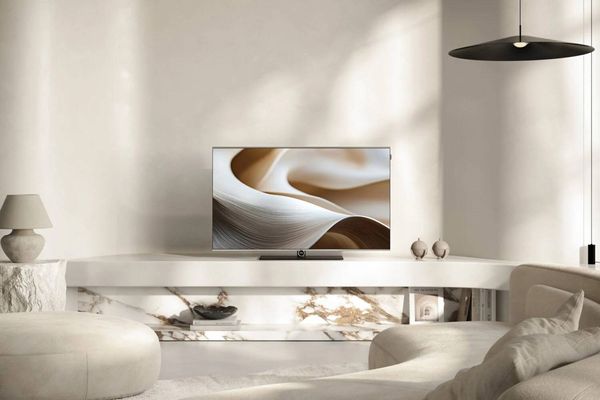 T&eacute;l&eacute;viseur OLED 4K Loewe Antares 42 int&eacute;gr&eacute; dans un salon contemporain, avec &eacute;cran allum&eacute; et design &eacute;pur&eacute; sur un meuble minimaliste.