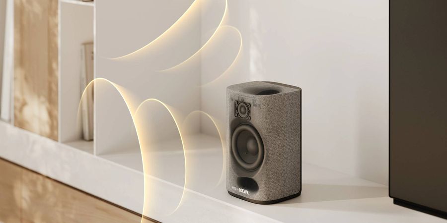 Enceinte satellite du syst&egrave;me home cin&eacute;ma sans fil Loewe We. BOOST avec haut-parleurs apparents, install&eacute;e sur un meuble contemporain.