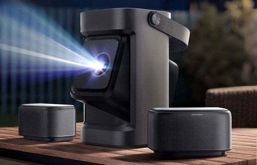 Projecteur Nebula P1 avec ses enceintes d&eacute;tachables et rechargeables pos&eacute; sur une table en ext&eacute;rieur, en pleine projection.