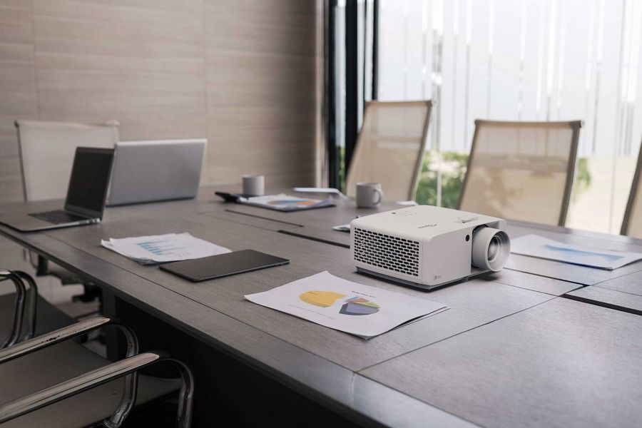 Vid&eacute;oprojecteur Optoma ZK551 pos&eacute; sur une table de r&eacute;union