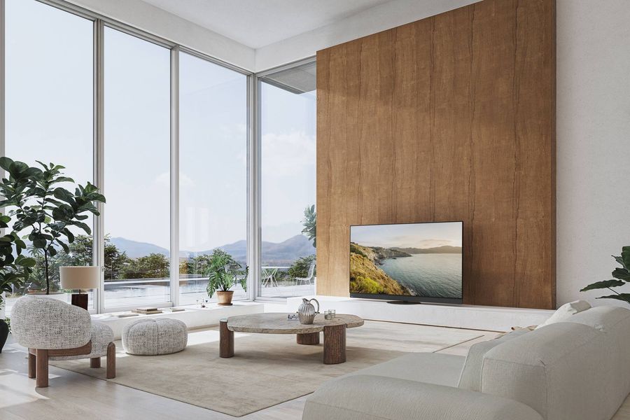 Téléviseur OLED Panasonic TV-65Z95B installé dans un salon lumineux, affichant une image de paysage côtier en ultra haute définition.