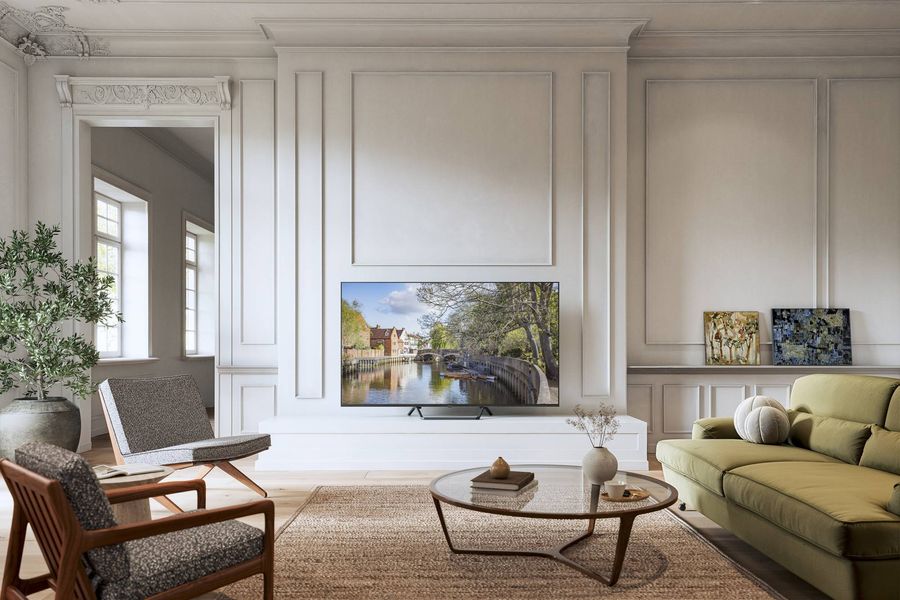  Téléviseur Panasonic TV-55W95BEG installé dans un salon, affichant une image détaillée d’un canal urbain.