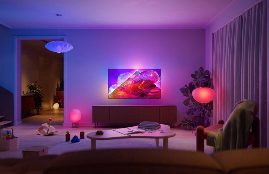 T&eacute;l&eacute;viseur Philips 50PQS9001 The One avec Ambilight affichant une image color&eacute;e dans un salon moderne &agrave; l'&eacute;clairage d'ambiance.