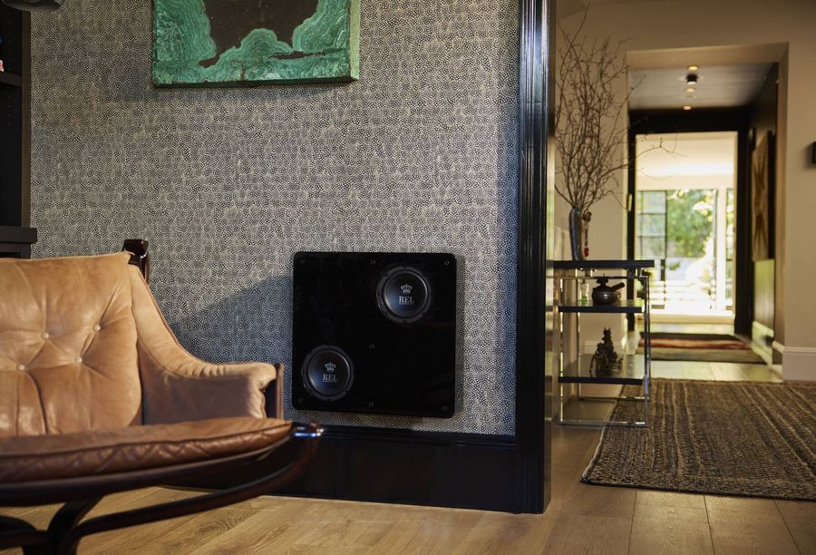 Caisson de basses REL Acoustics Planar PL1 int&eacute;gr&eacute; discr&egrave;tement au mur d&rsquo;un int&eacute;rieur r&eacute;sidentiel contemporain et &eacute;l&eacute;gant.
