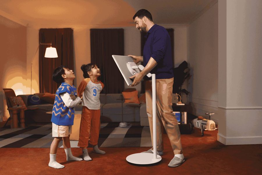 Homme et enfants interagissant autour d&rsquo;un &eacute;cran connect&eacute; Samsung The MovingStyle 27LSM7FA mont&eacute; sur pied ajustable en hauteur.