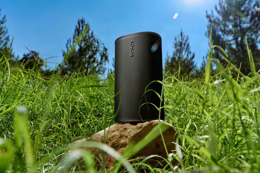 Sonos Play noire sur un rocher &agrave; l'ext&eacute;rieur avec de l'herbe et du soleil