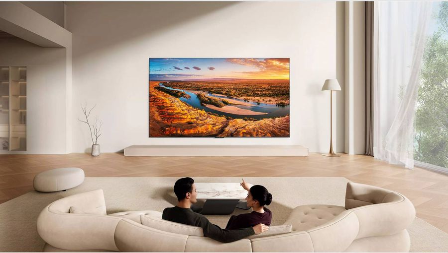 T&eacute;l&eacute;viseur 4K RGB Mini LED TCL 85RM9L install&eacute; dans un salon moderne, affichant un paysage naturel aux couleurs riches et d&eacute;taill&eacute;es.