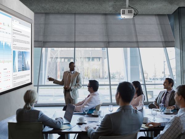 Vid&eacute;oprojecteur Viewsonic LS401HD projetant une pr&eacute;sentation professionnelle avec graphiques d&eacute;taill&eacute;s dans une salle de r&eacute;union moderne lumineuse.