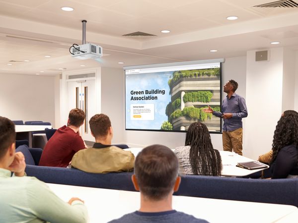 Vid&eacute;oprojecteur Viewsonic LS401HD projetant une pr&eacute;sentation visuelle nette dans une salle de formation moderne avec participants attentifs.