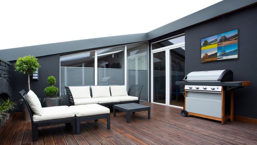 Vue d'une TV d'extérieur sur une terrasse, à proximité d'un barbecue