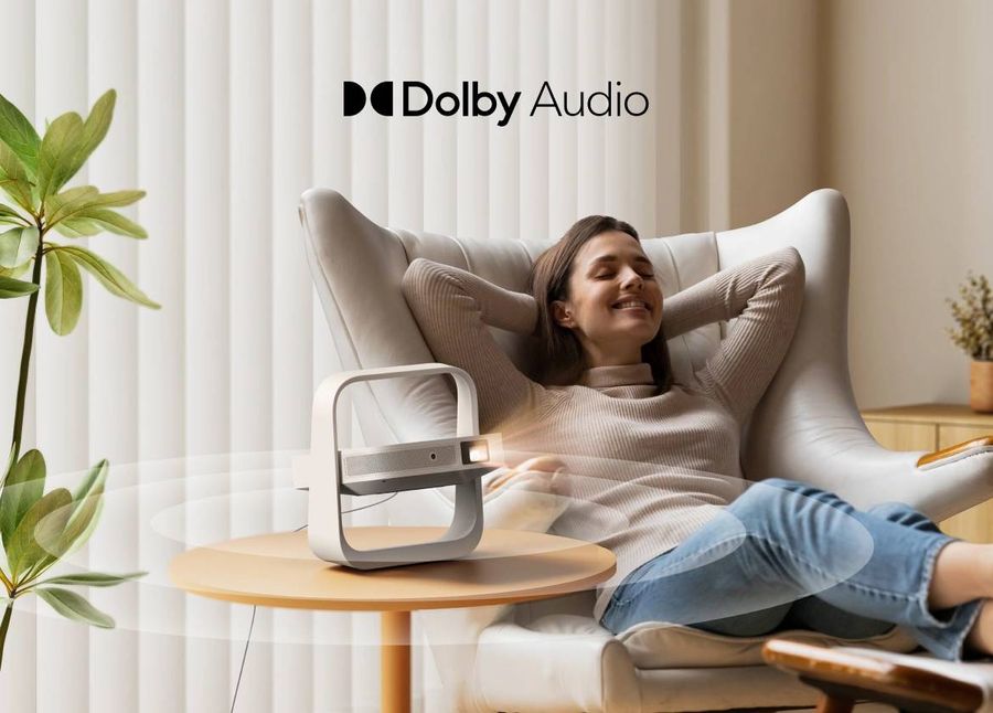 Le projecteur Xgimi Elfin Flip Plus diffuse un son Dolby Audio depuis une table d&rsquo;appoint dans un salon.