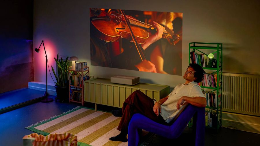 Vid&eacute;oprojecteur ultra courte focale Xgimi Mira Laser Ultra HD 4K diffusant un concert dans un salon pour illustrer ses performances audio.