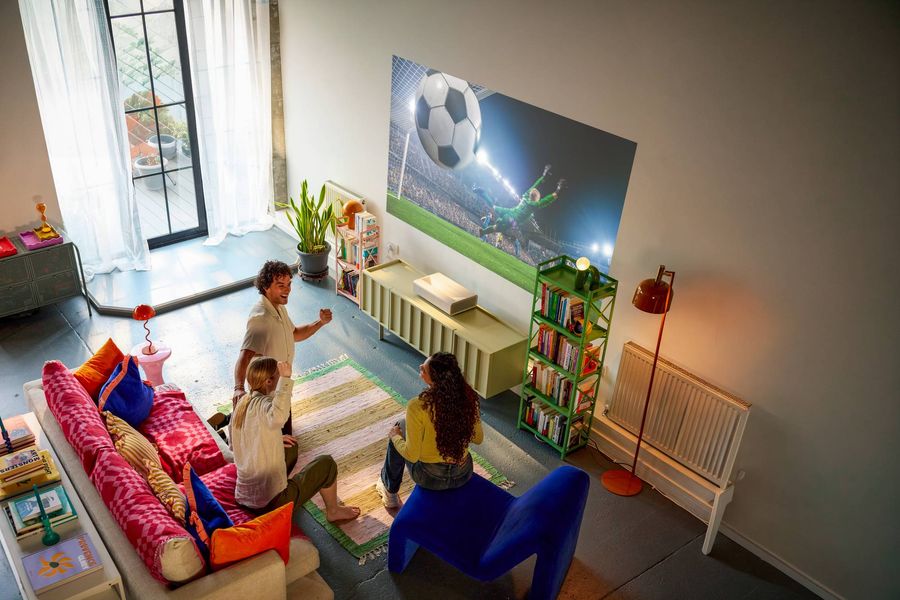 Vid&eacute;oprojecteur 4K ultra courte focale XGIMI MIRA Pro projetant un match de football en grand format dans un salon lumineux.