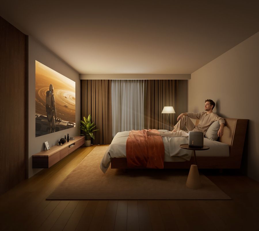 Un homme regarde un film de science-fiction projeté en Full HD HDR par le mini projecteur Xming Page Two dans une chambre.